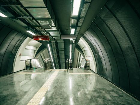 Sleek and modern interior of Istanbul subway station with escalators and clean lines.
