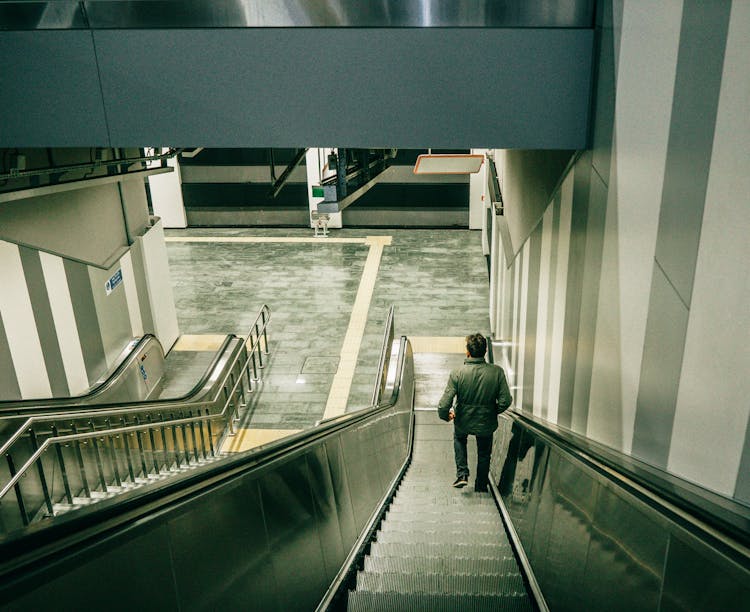 A Person Going Down An Escalator