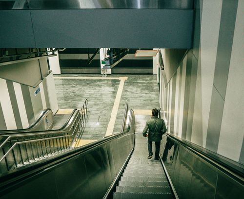 Free A solitary man riding down an escalator inside a modern Istanbul metro station. Stock Photo