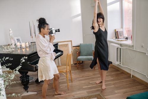 Free A happy couple enjoying dancing and filming in a cozy home setting. Stock Photo