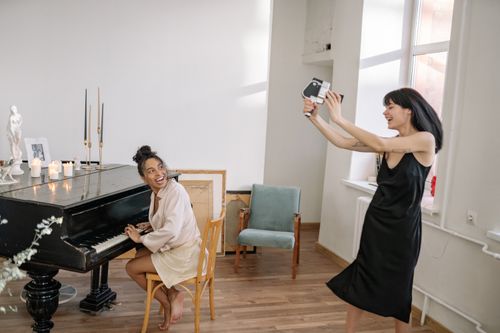 Free A joyful indoor scene with friends enjoying music and photography. Stock Photo