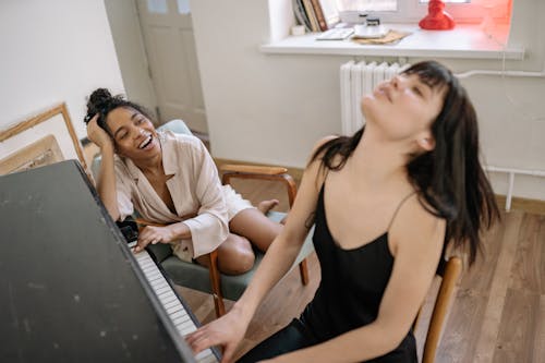 Free Woman in Black Spaghetti Strap Dress Playing Piano Stock Photo