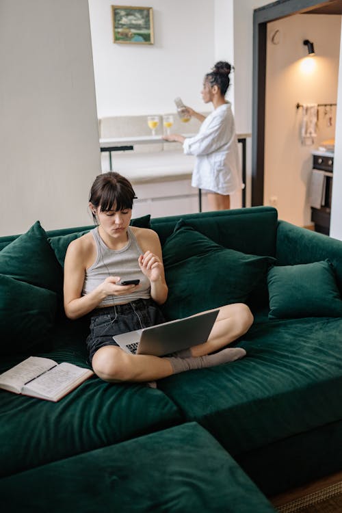 A Woman Sitting on the Couch While Using Her Computer