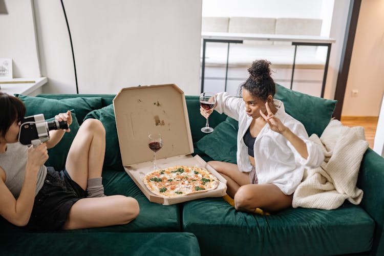 Two Girls Sitting On Green Couch