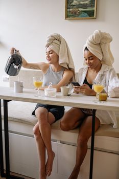 Two women share a joyful morning with breakfast and laughter in a cozy home setting