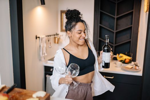 Photo of a Woman Dancing while Holding a Bottle of Wine