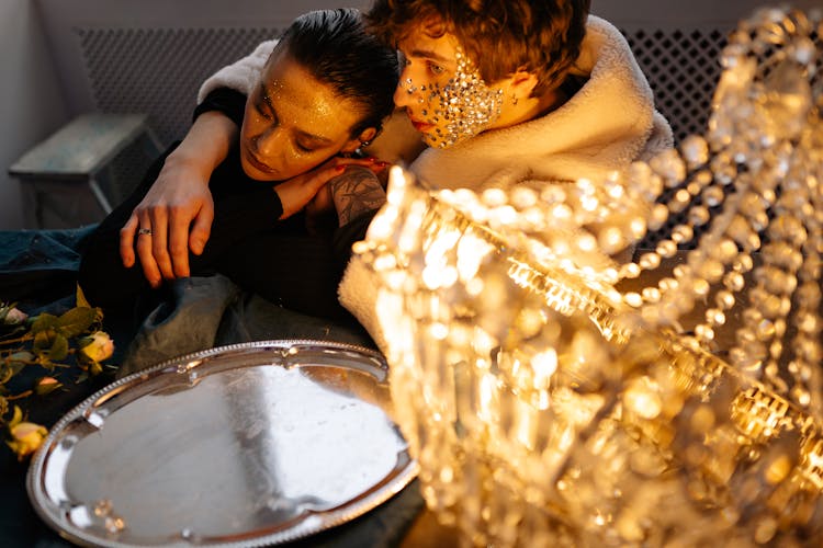 A Man And A Woman Near A Silver Plate And Chandelier