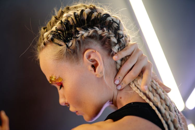 A Woman With Braided Hair And  Ear Piercings