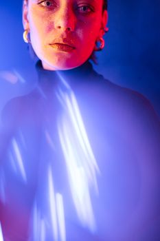 Artistic portrait of a woman with neon lighting and glitter makeup, exuding a vibrant and modern vibe.