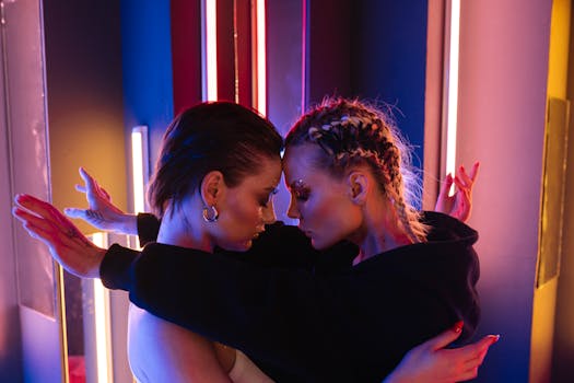 Stylish and artistic portrait of two women embracing under vibrant neon lights, expressing emotion and connection.