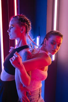 Stylish models posing under neon lights showcasing glitter makeup and modern fashion.