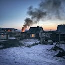 清晨，俄罗斯一个白雪皑皑的村庄上空，房屋升起烟雾