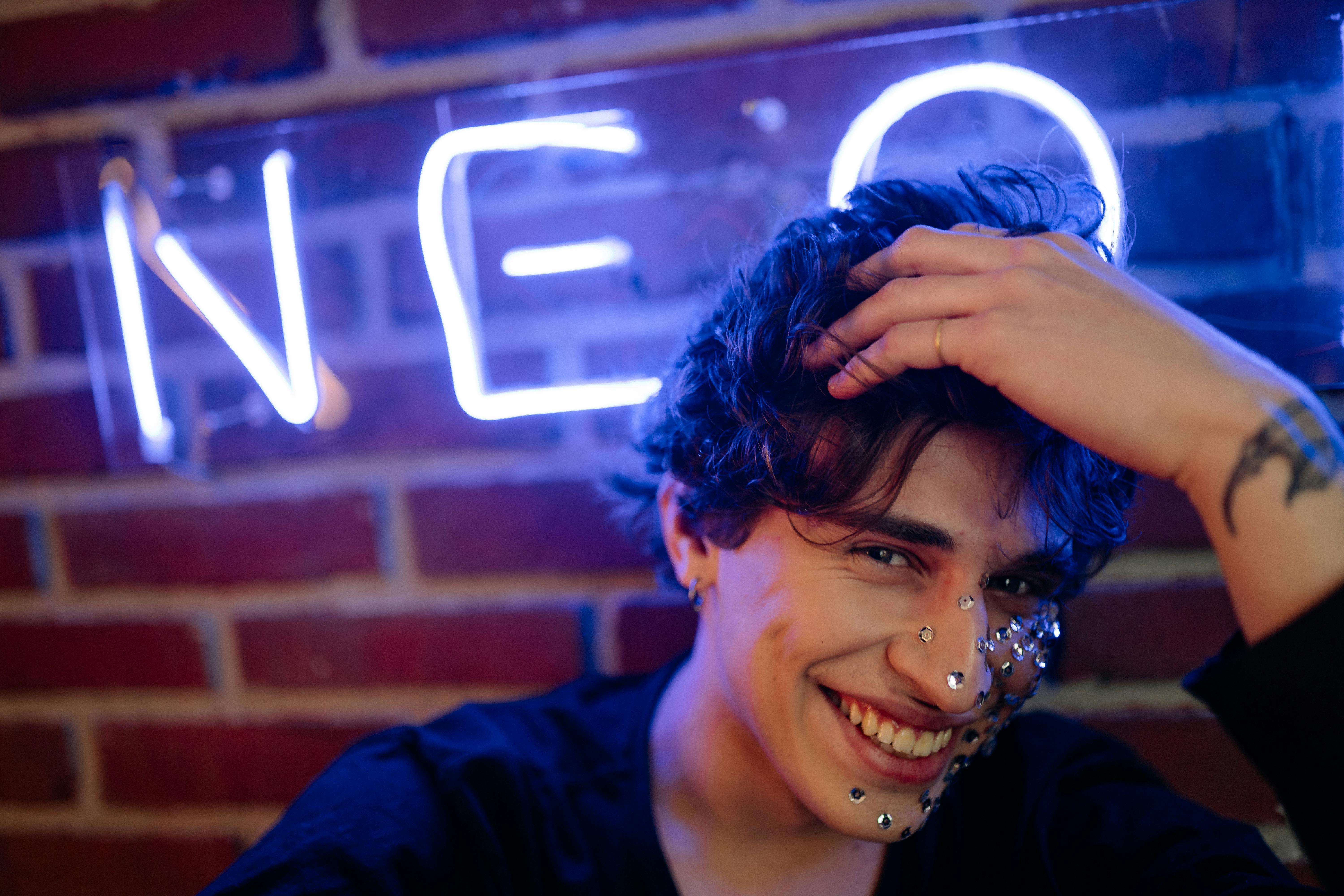 a man with silver sequins on his face smiling at the camera