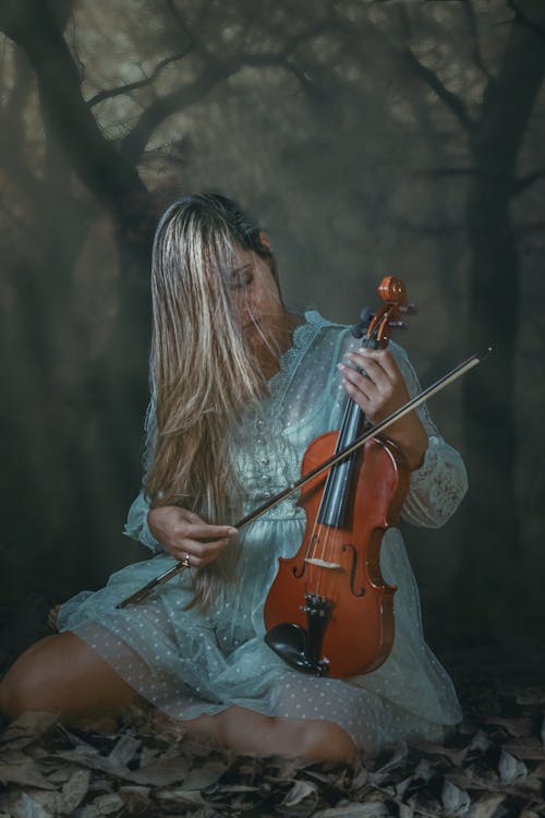 A Blonde-Haired Woman in a Dress Playing Violin