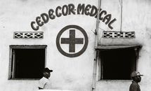 Black and white image of CEDECOR Medical with two men walking past the building's exterior.