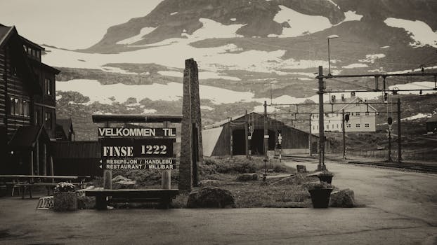 这张黑白照片拍摄于芬塞火车站，背景是雪山