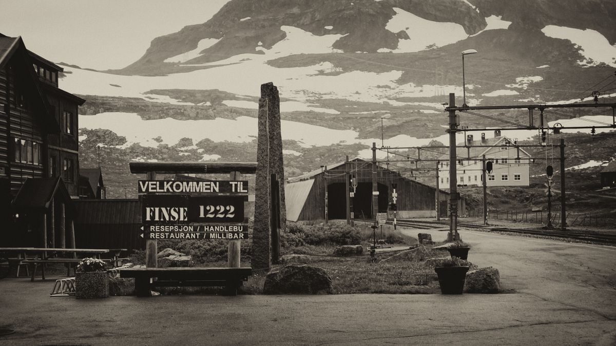 Finse station in black and white with snowy mountains behind