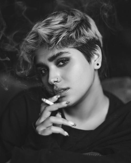 Free Monochrome Photo of a Woman with a Nose Piercing Smoking a Cigarette Stock Photo