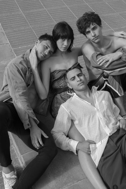 Captivating monochrome portrait of four relaxed young adults sitting closely.