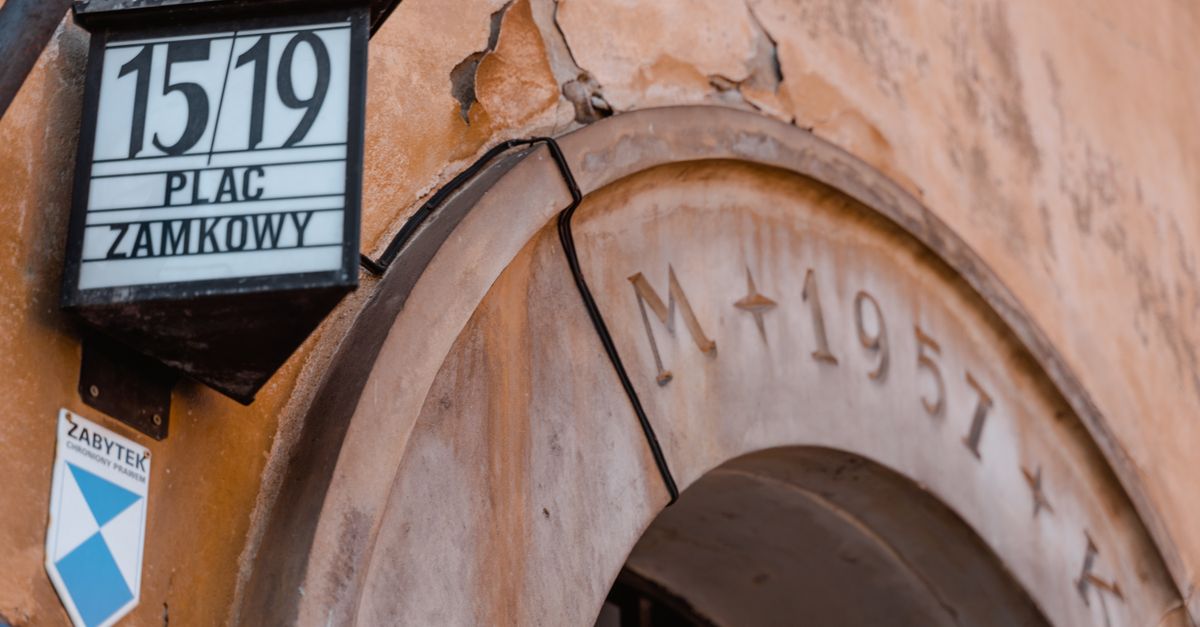 Close-up of a historic archway at Plac Zamkowy, displaying architectural details and signage.
