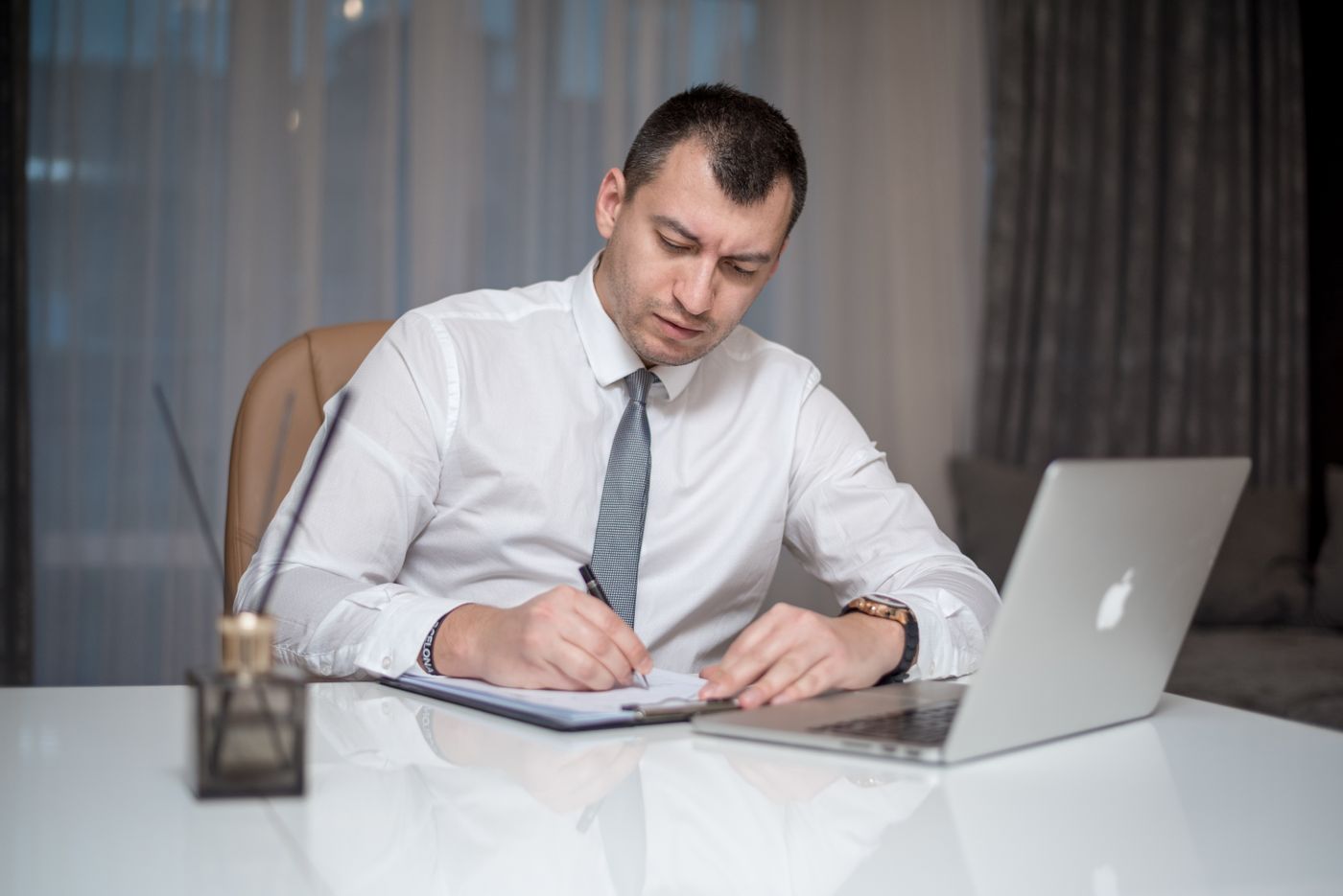 Sales manager reviewing two conflicting reports at his desk