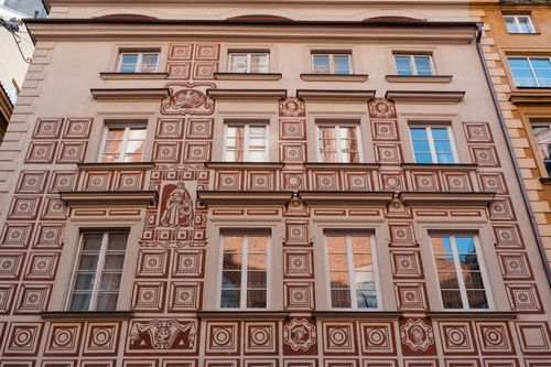 Free Detailed view of an intricately patterned facade of a European building with glass windows. Stock Photo