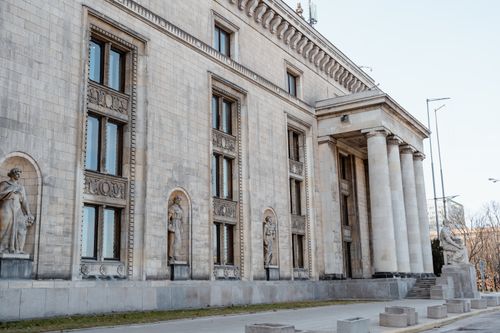 Free Historic neoclassical building facade with statues and columns in a city. Stock Photo