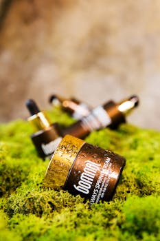 Close-up of cosmetic bottles on vibrant moss, showcasing natural beauty products.