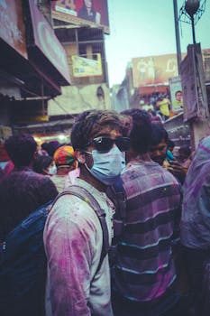 Vibrant Holi celebration with people enjoying colors in an Indian street festival.