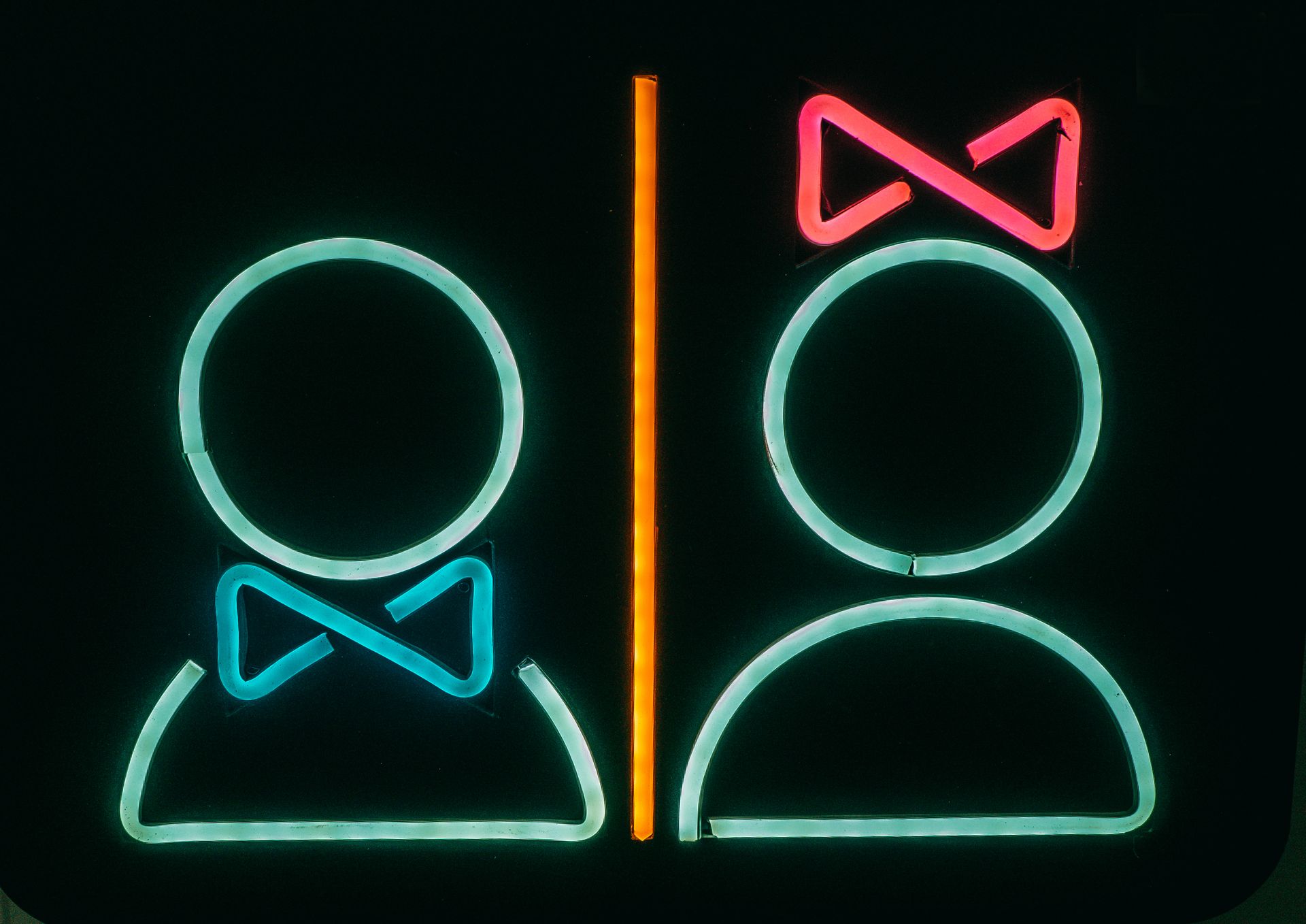 Bright neon bathroom sign with male and female symbols, vibrant and modern.