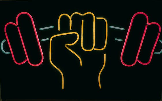 Colorful neon sign of a fist holding dumbbells, showcasing strength and fitness.