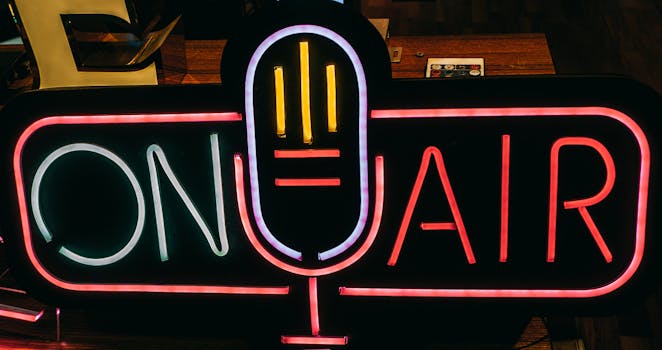 Bright neon 'On Air' sign glowing in a dark studio, perfect for broadcasting themes.