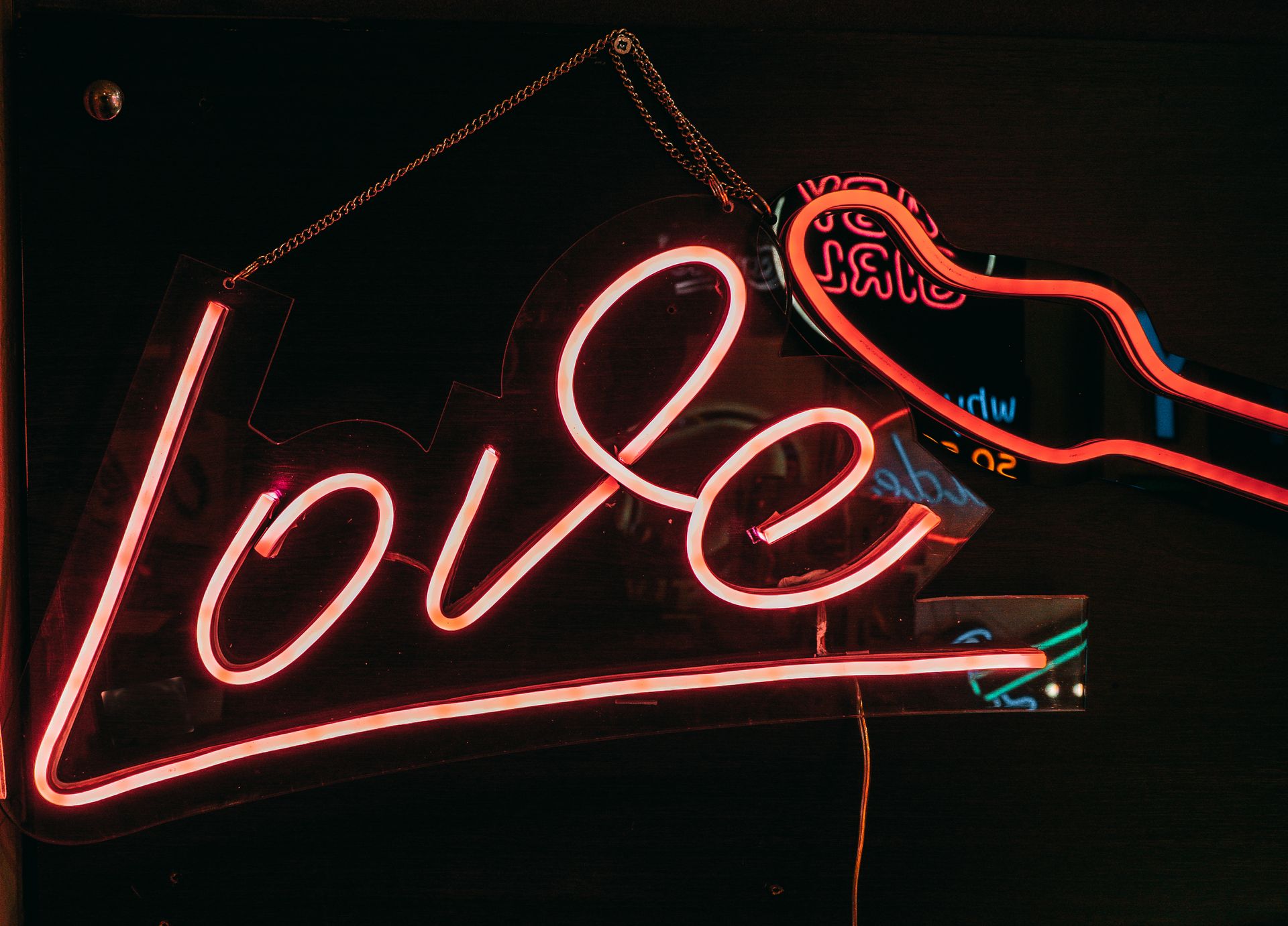Bright neon 'Love' sign hanging indoors, captured in Istanbul's vibrant nightlife setting.