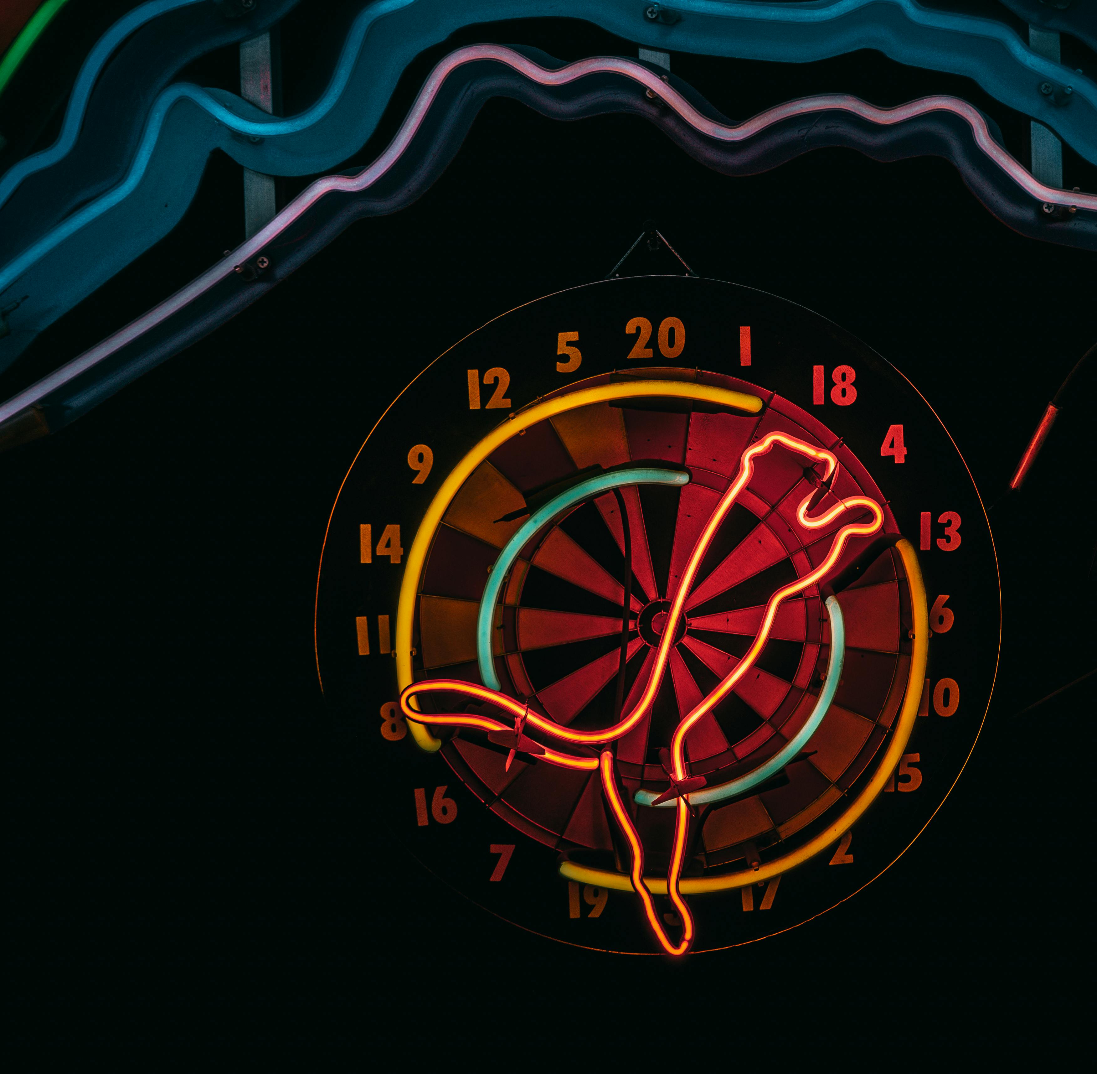 Vibrant neon-lit dartboard against a dark background in İstanbul's nightlife scene.