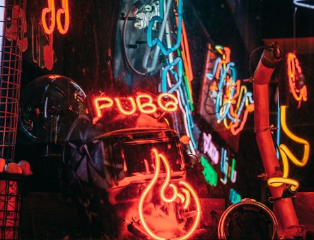 Colorful neon signs and reflections create a vibrant scene in İstanbul's nightlife.