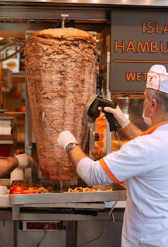 Street vendor slicing delicious doner kebab in Istanbul's bustling markets, a taste of traditional Turkish street food.