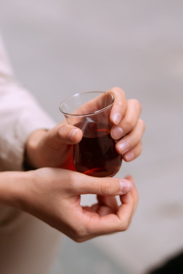 A Person Holding A Glass