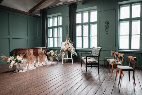 A quiet memorial room with flowers and empty chairs