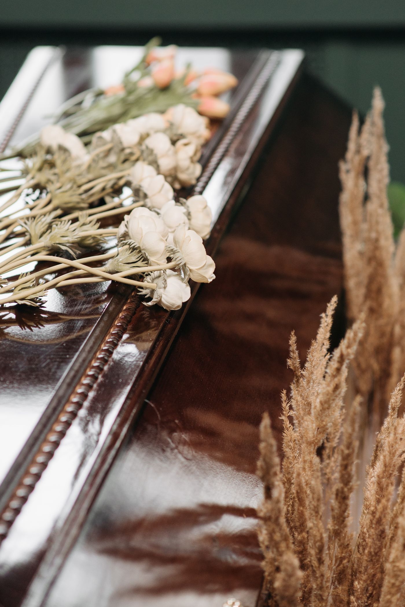 Polished casket adorned with white flowers