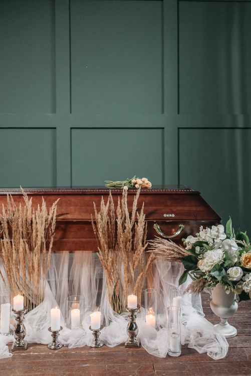Peaceful funeral setting with lit candles and floral arrangements for a memorial service