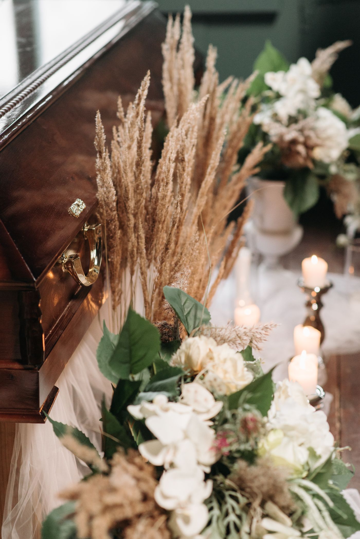 Funeral coffin surrounded by flowers and candles
