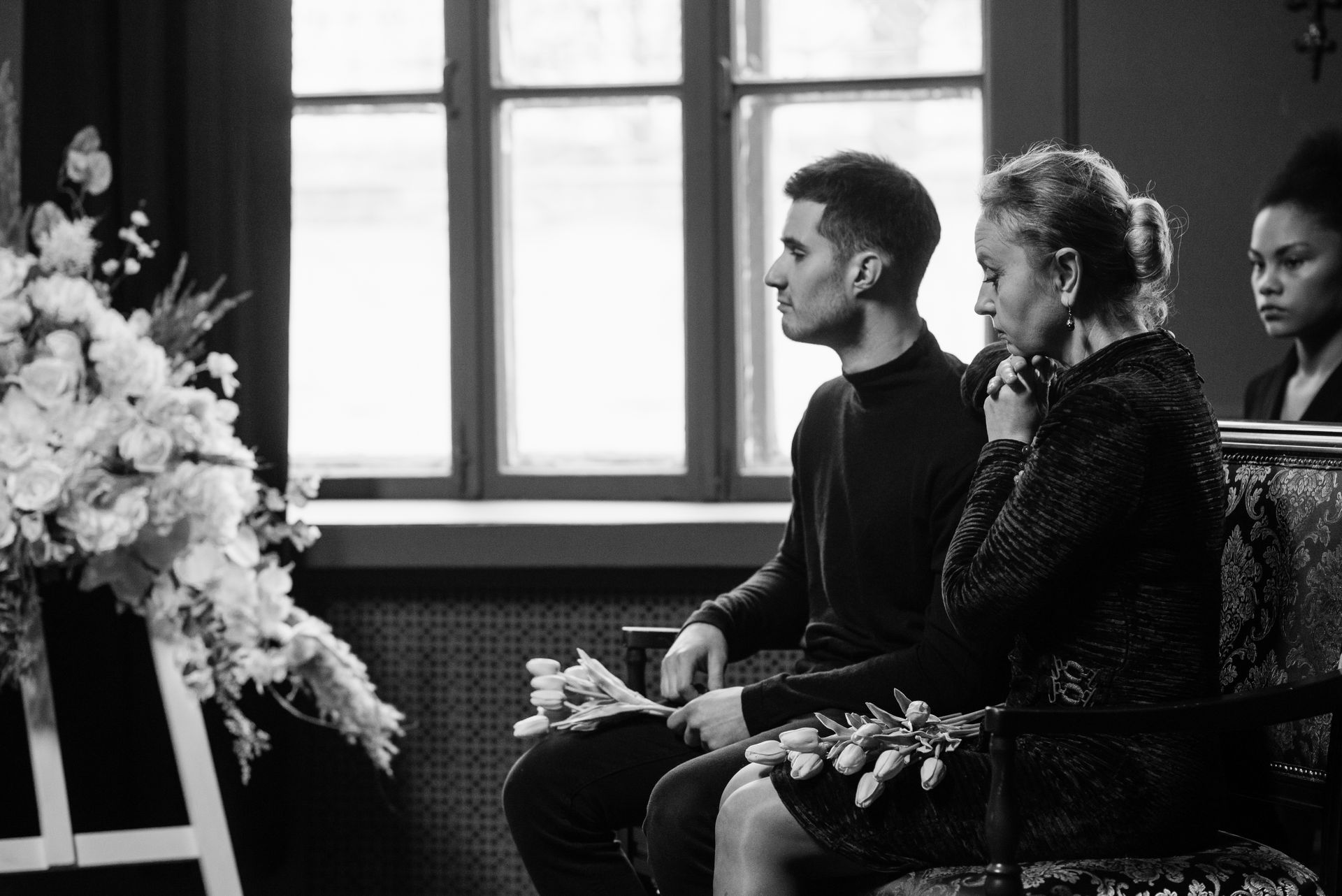 A touching grayscale image of family members attending a funeral and paying their respects.