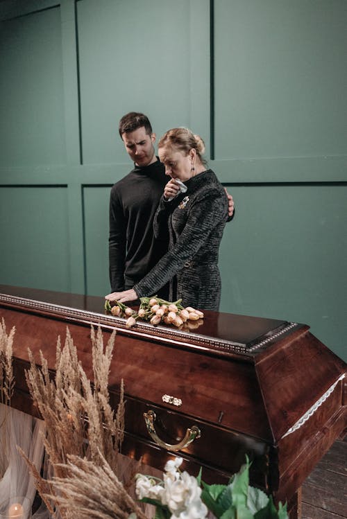 Man and Woman Standing Beside the Coffin