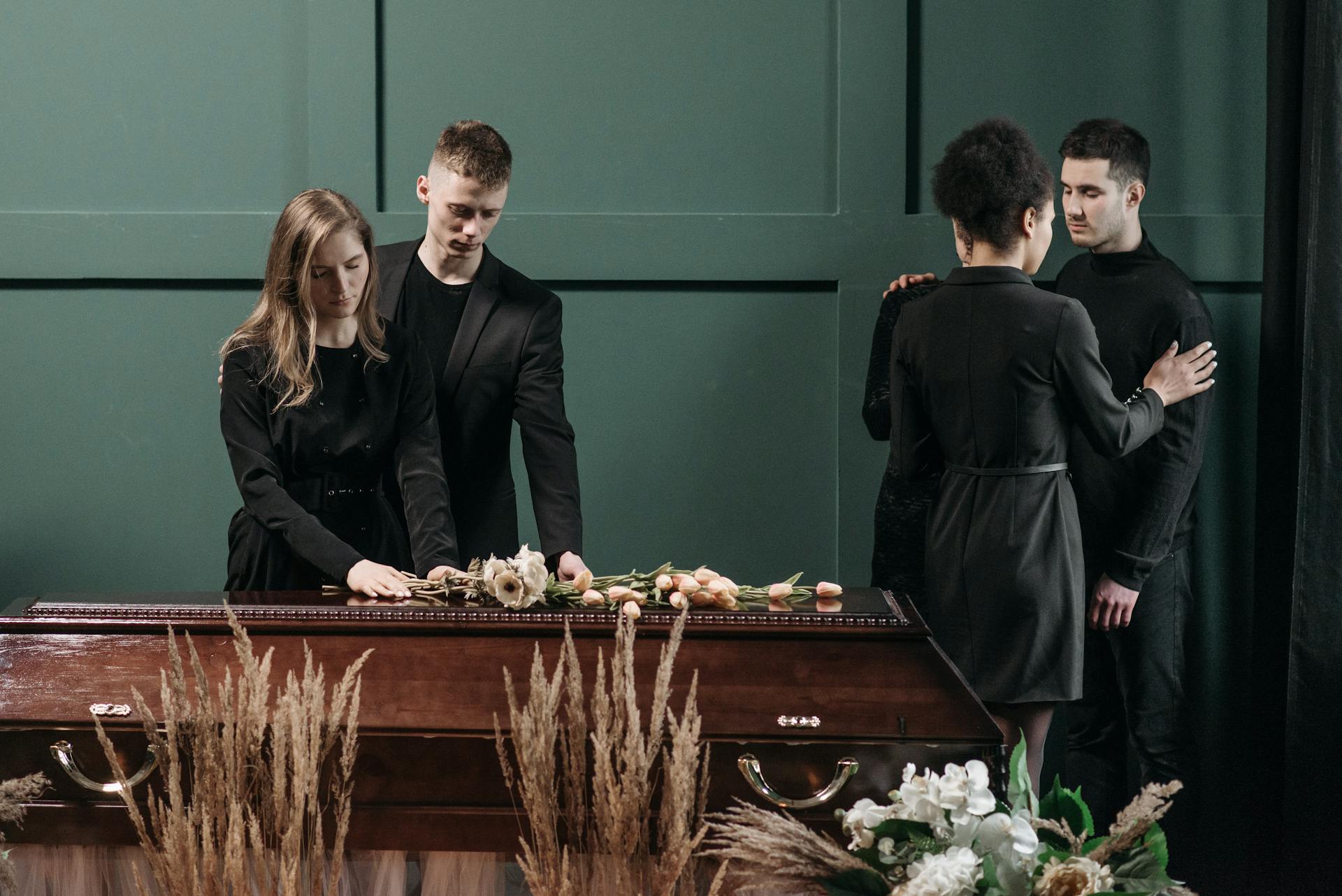 A touching funeral scene with people paying respects to a loved one.