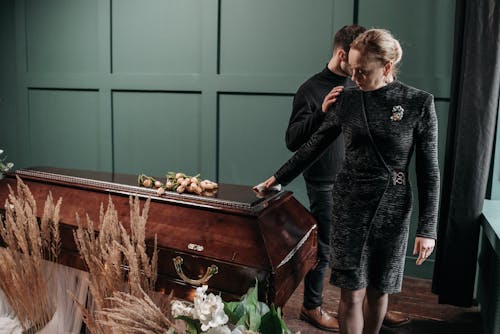 Free Man and Woman Standing Beside the Coffin Stock Photo