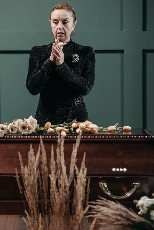A coffin adorned with flowers during a quiet service
