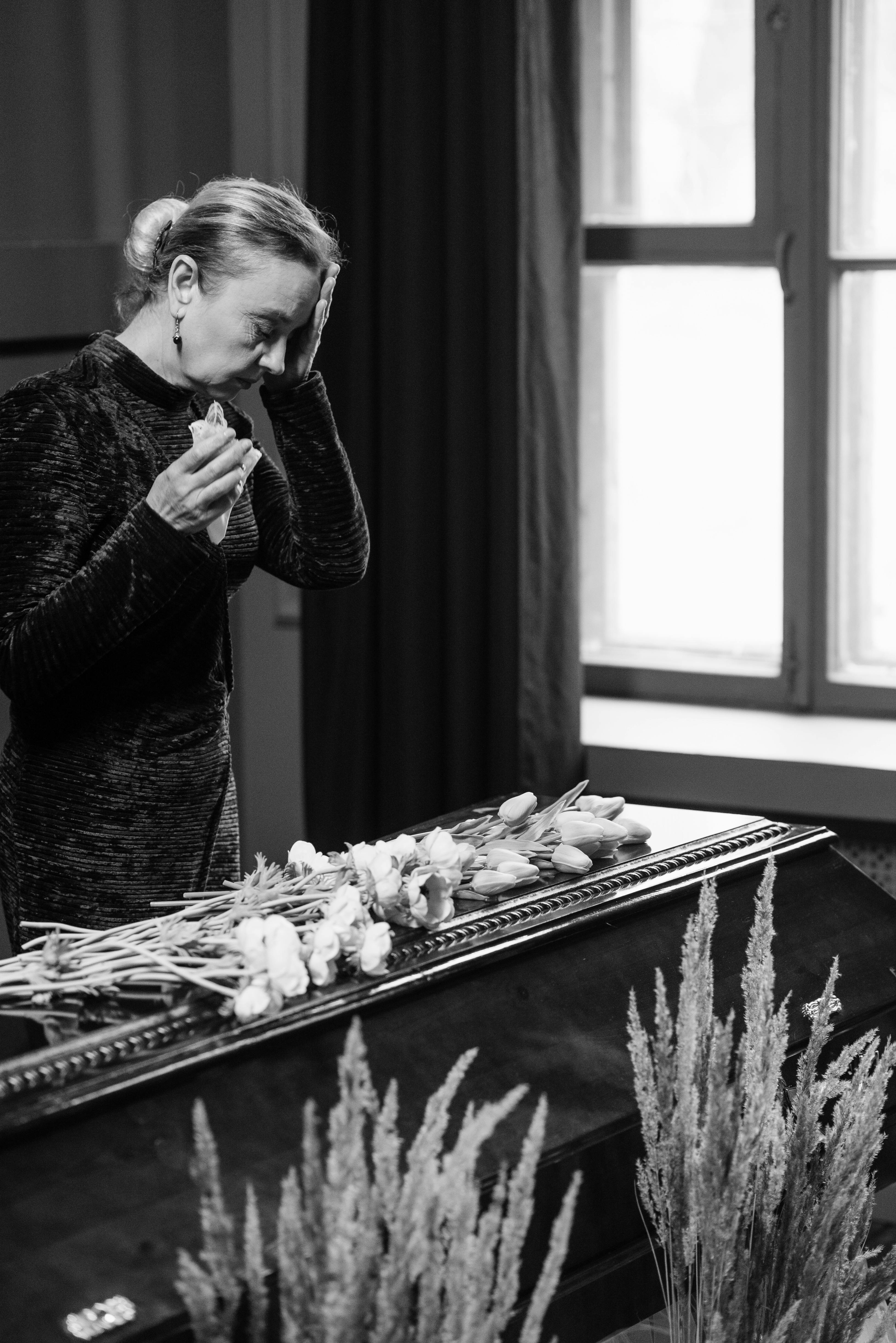 a woman standing beside the coffin