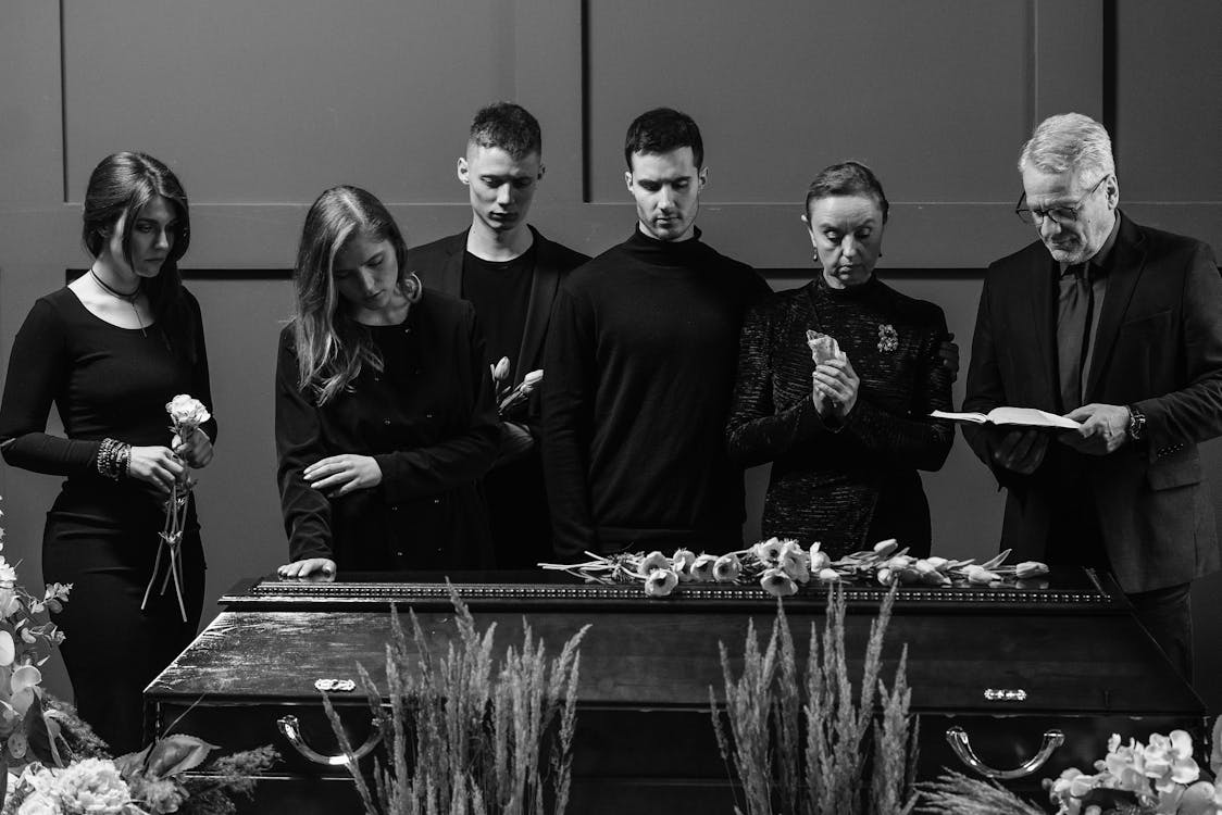 Free A Group of People Standing Near a Wooden Coffin Stock Photo