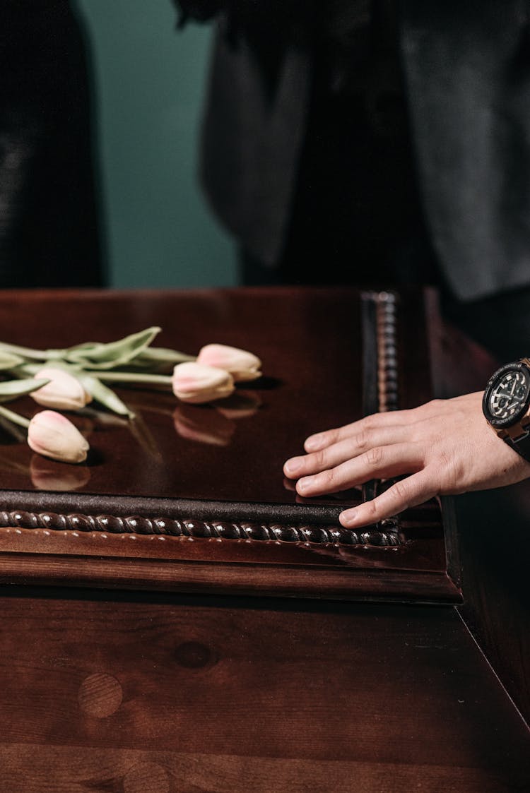 A Person Touching A Wooden Surface With Flowers