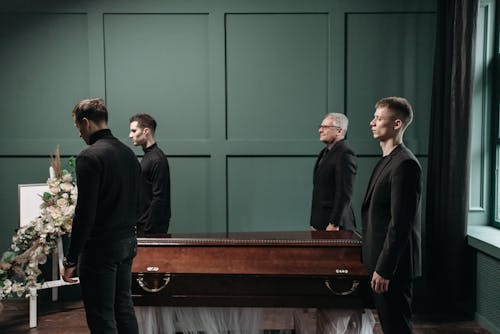 Free Men Standing Near the Coffin Stock Photo